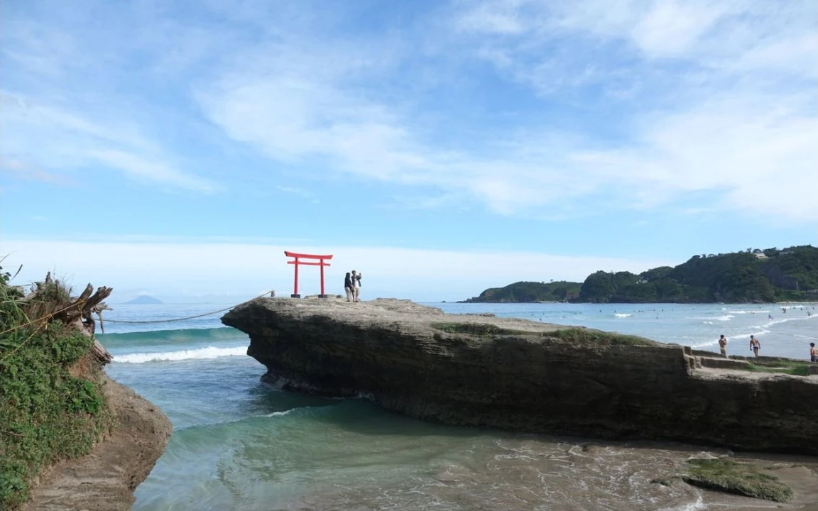 白浜の海辺に立つ、赤い鳥居。