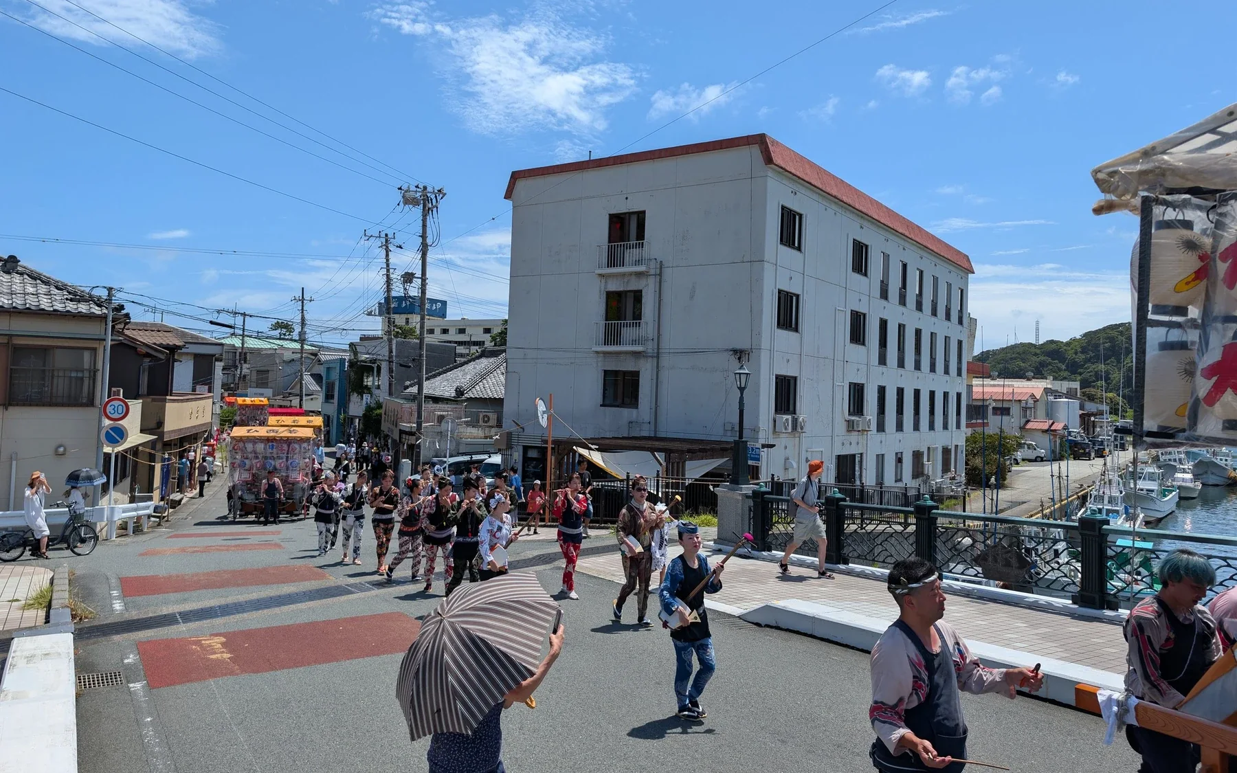 風まちの前を、祭りの行列が通る。