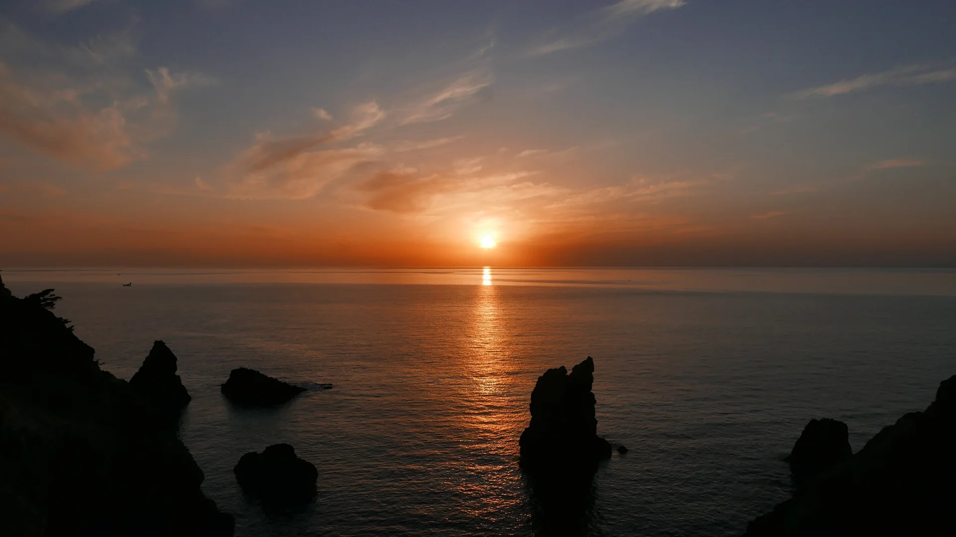 海に沈む夕日と、岩々のシルエット