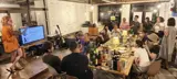 司会を囲んで、食事と会話を楽しむパーティー。