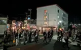 祭りの夜、風まちの前を行く人々。