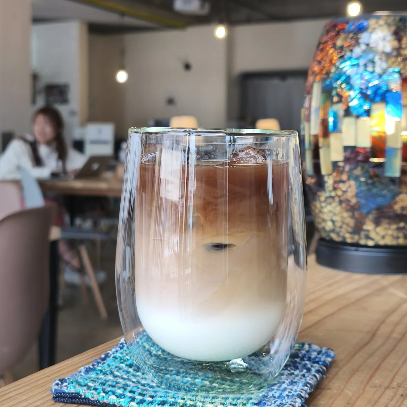 カフェオレのグラスと、色とりどりのランプ。
