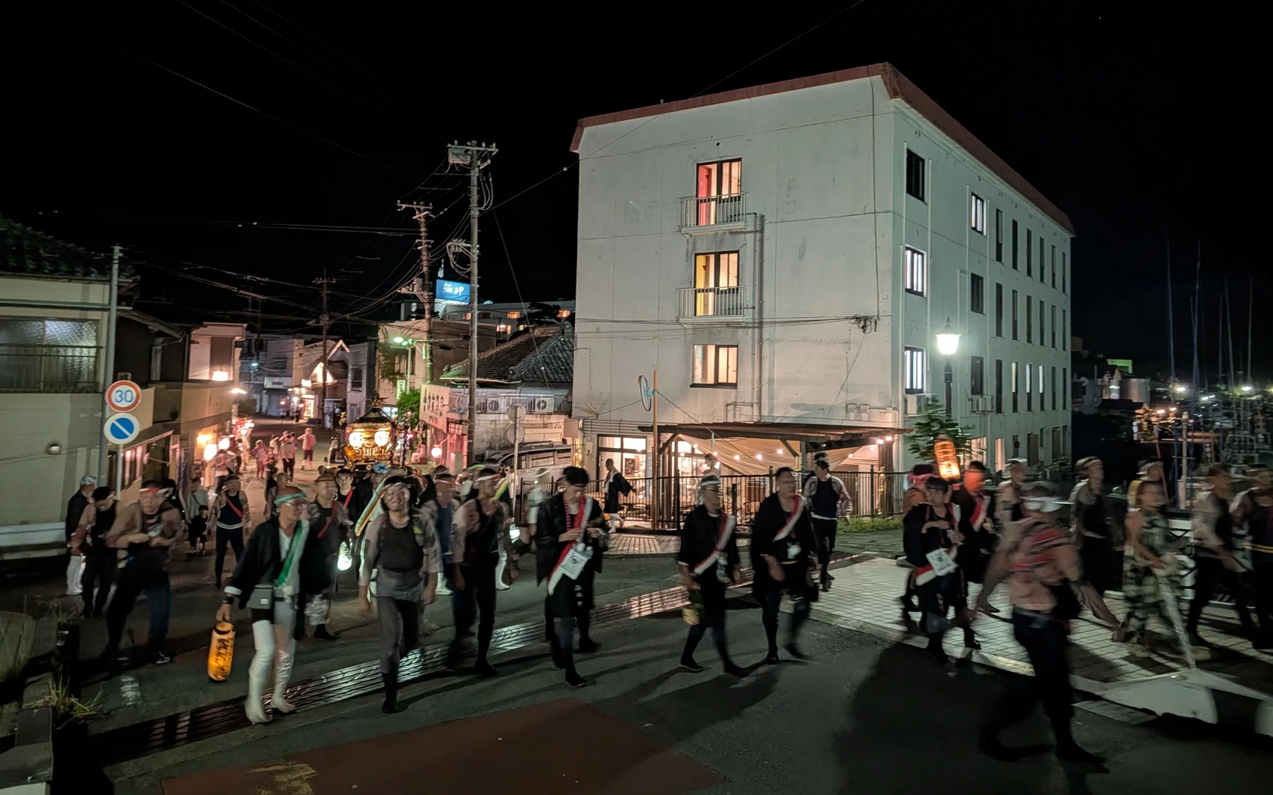祭りの夜、風まちの前を行く人々。