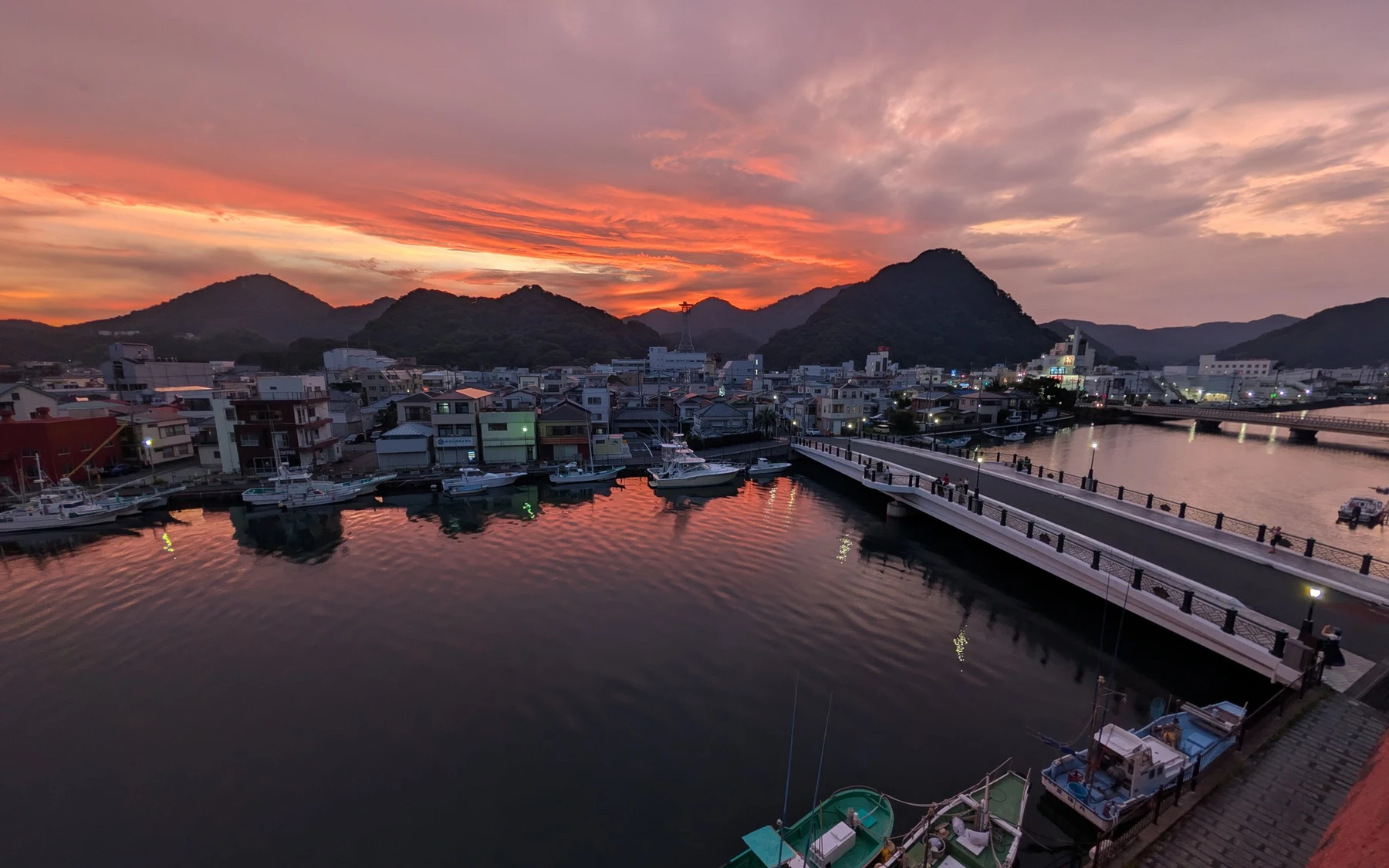 港側の部屋からの眺め。夕焼けに染まる下田のまちと水面。
