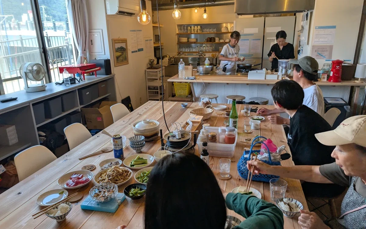 共用キッチンで料理をする人と、食卓を囲む人。